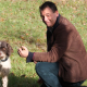 Xavier Mathiaud accroupi auprès de son lagotto romagnolo, parmi de jeunes arbres